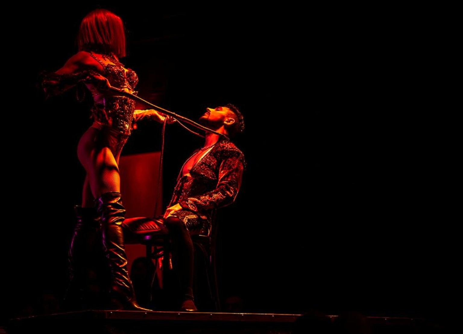Rouge Las Vegas performers in a red-lit chair duet